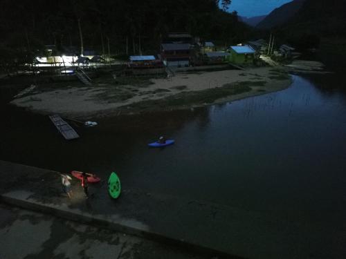 a person standing on the shore of a body of water at SAHATI HOMESTAY PAYAKUMBUH & Swimingpool in Payakumbuh