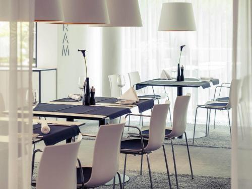 a dining room with tables and chairs with bottles on them at Congress Hotel Mercure Nürnberg an der Messe in Nürnberg
