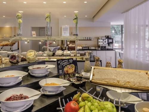 a kitchen with bowls of food on a counter at Congress Hotel Mercure Nürnberg an der Messe in Nürnberg