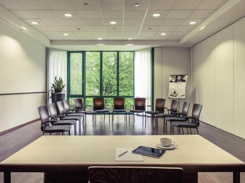 an empty meeting room with a table and chairs at Congress Hotel Mercure Nürnberg an der Messe in Nürnberg