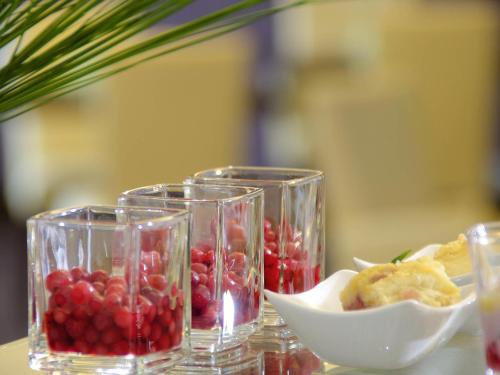 a table with three glasses and a bowl of fruit at Mercure Hotel Hagen in Hagen