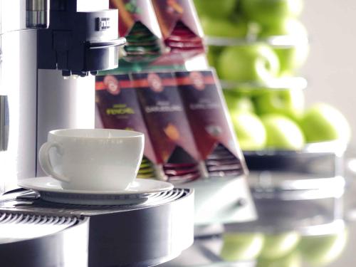 a coffee cup sitting on top of a coffee machine at Mercure Hotel Hagen in Hagen