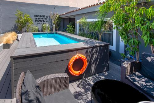 a swimming pool with an orange kayak on a patio at Aqua Bliss Piraeus in Piraeus