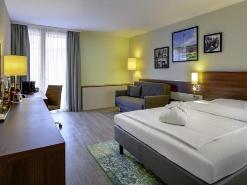 a hotel room with a bed and a couch at Mercure Stuttgart Sindelfingen an der Messe in Sindelfingen