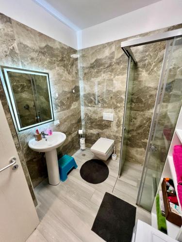 a bathroom with a shower and a sink and a toilet at Three above Sea apartment in Golem