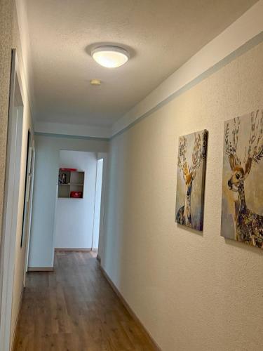 a hallway with paintings of deer on the walls at AH Carinthia Mallnitz - Carinthia Appartements in Mallnitz