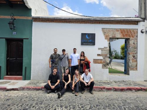 a group of people posing in front of a building at Blue Moon Hostel in Antigua Guatemala