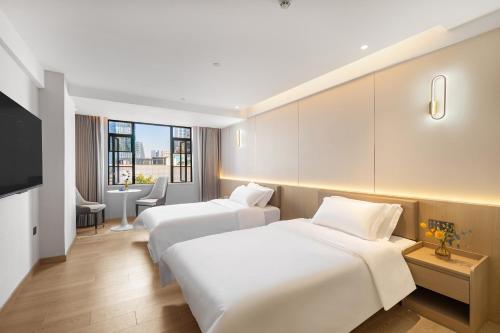 a hotel room with two beds and a television at Guangzhou Xingdu International Hotel in Guangzhou