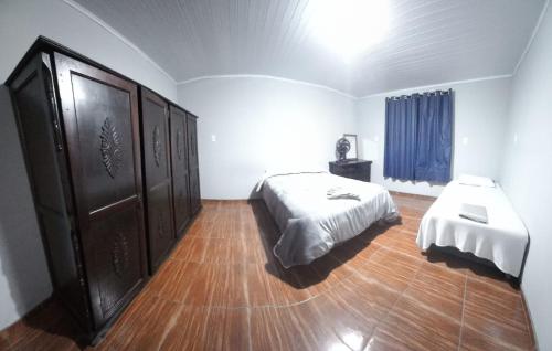a bedroom with a bed and a dresser at Casa de Hóspedes Espaçosa - Auto Check-In - Mafra SC in Mafra