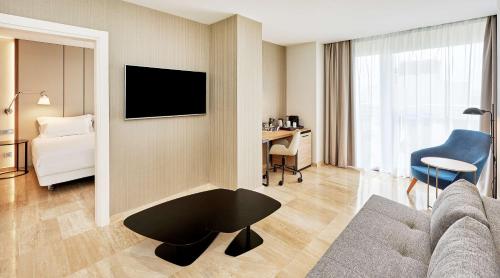 a living room with a couch and a table at NH Imperial Playa in Las Palmas de Gran Canaria