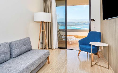 a living room with a couch and a table at NH Imperial Playa in Las Palmas de Gran Canaria