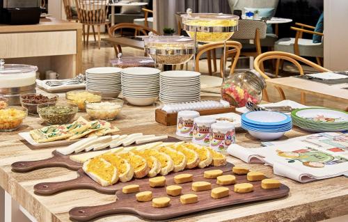 a table with food and plates and a cutting board at NH Imperial Playa in Las Palmas de Gran Canaria