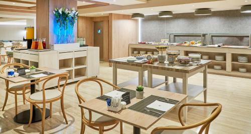 a restaurant with tables and chairs in a kitchen at NH Imperial Playa in Las Palmas de Gran Canaria