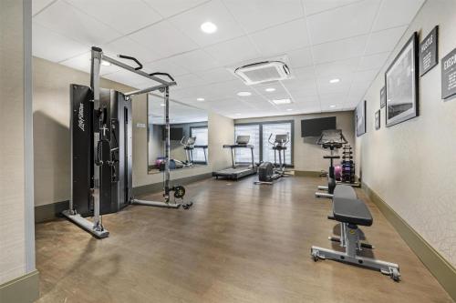 a gym with several treadmills and cardio machines at Best Western Potsdam University Park Inn in Potsdam