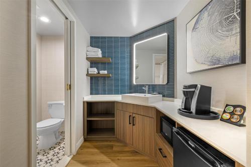 a bathroom with a sink and a toilet and a mirror at Best Western Potsdam University Park Inn in Potsdam