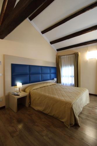 VazzolaにあるHotel Villa Materniniのベッドルーム1室(大型ベッド1台、青いヘッドボード付)