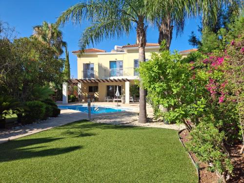 una villa con piscina y palmeras en Latchi coast villa-resort, en Lachi