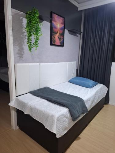a bedroom with a white bed with a blue blanket at Studio Liberdade - Próx Metrô - Sé in Sao Paulo