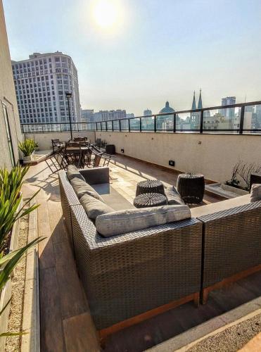 a balcony with two couches on the roof of a building at Studio Liberdade - Próx Metrô - Sé in Sao Paulo
