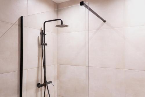 a shower with a glass door in a bathroom at Piedra Luxury Apartments in Nafplio