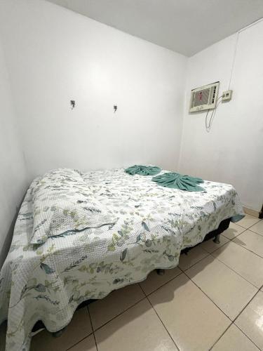un letto in una stanza con una coperta sopra di Quarto no centro 310 a Manaus