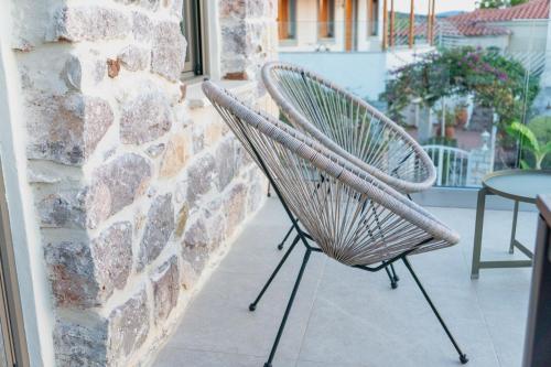 a chair sitting on a porch next to a brick wall at Piedra Luxury Apartments in Nafplio