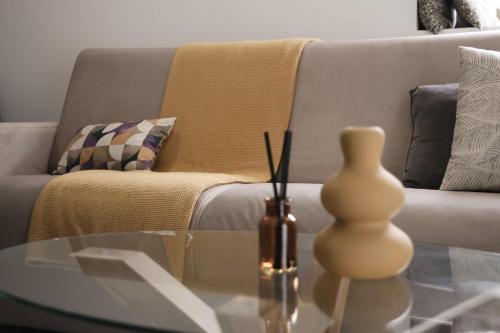 a glass coffee table with a vase on top of it at Piedra Luxury Apartments in Nafplio