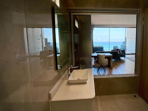 a bathroom with a sink and a view of a living room at Fins Dream Villas in Fins