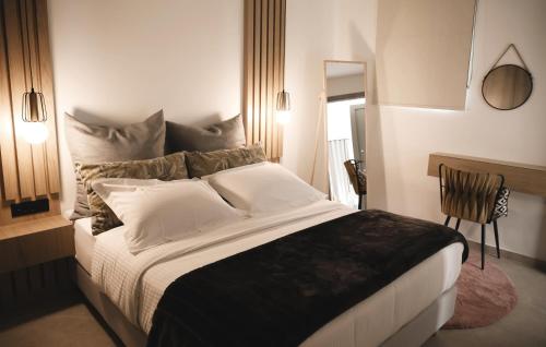 a bedroom with a large bed and a chair at Piedra Luxury Apartments in Nafplio