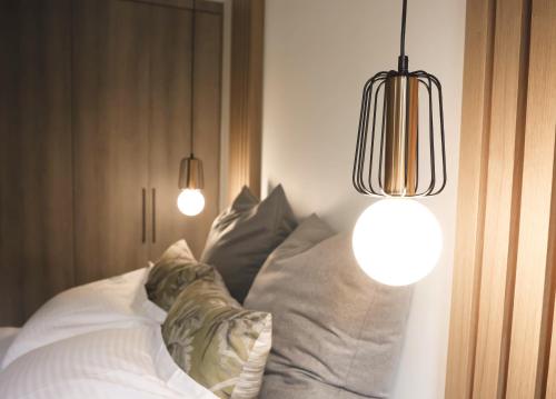 a bedroom with two lights and a bed with pillows at Piedra Luxury Apartments in Nafplio