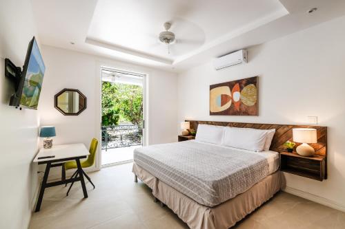 a bedroom with a bed and a desk and a window at Villa Harmonia in Potrero