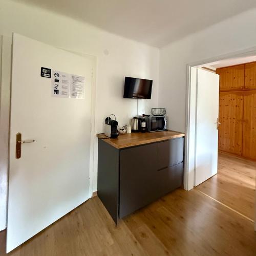 a kitchen with a counter with a microwave and a door at AH Carinthia Mallnitz - Carinthia Appartements in Mallnitz