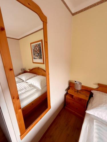 a small bedroom with a mirror and a bed at AH Carinthia Mallnitz - Carinthia Appartements in Mallnitz