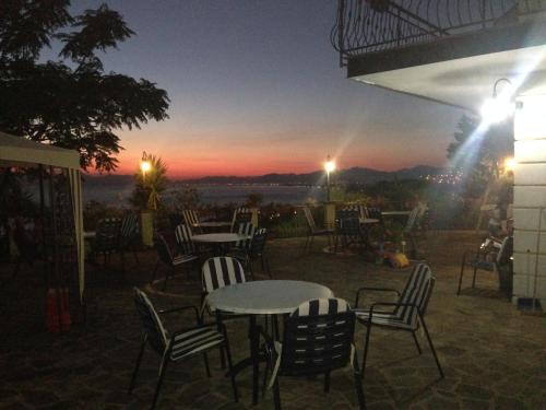 a group of tables and chairs with a sunset in the background at Villa Malandrino Guest House in Agropoli