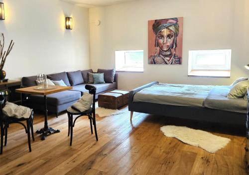 a living room with a bed and a couch at La Bohème Lodges and Glamping in Vrhaveč