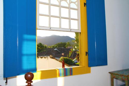 a window with a view of a mountain at Pousada do Cais in Paraty