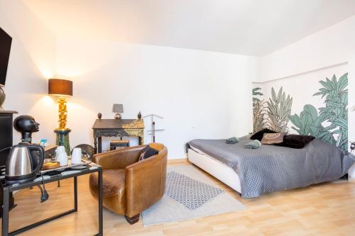 a bedroom with a bed and a chair at L'Eclose in Le Guilvinec