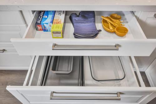 a white drawer with shoes and other items in a refrigerator at Luxe 4BR Retreat w Heated Pool Hot Tub and BBQ in Whitby