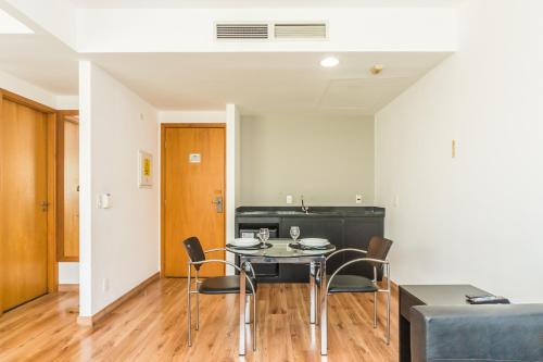 a dining room with a table and chairs at Paraíso Suítes by Charlie in Sao Paulo