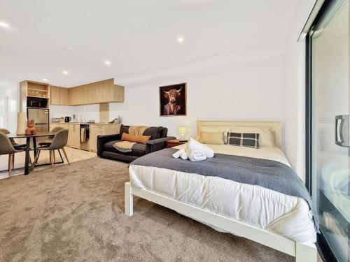 a bedroom with a bed and a living room at Cozy Studio with Private Yard in Christchurch CBD in Linwood