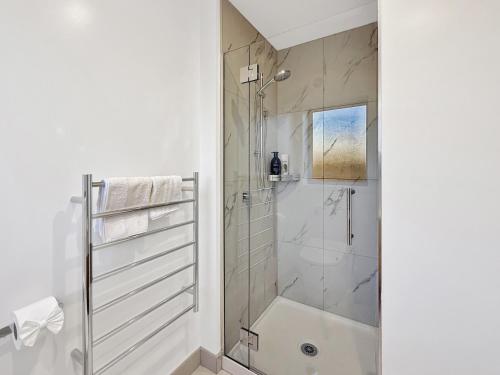 a white bathroom with a shower and a tub at Cozy Studio with Private Yard in Christchurch CBD in Linwood