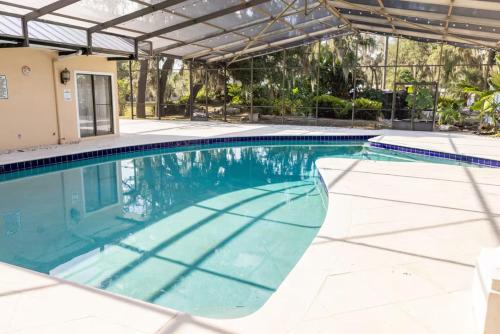 an indoor swimming pool with an umbrella over it at Spacious Luxury Estate Pool Jacuzzi Horses in Orlando