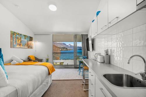 eine Küche mit einem Bett und einem Waschbecken in einem Zimmer in der Unterkunft Lakeview Lookout - Studio Unit in Queenstown Airport