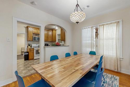 a dining room with a wooden table and blue chairs at Sea Glass Cottage in Galveston