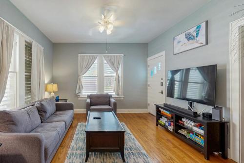 a living room with a couch and a tv at Sea Glass Cottage in Galveston