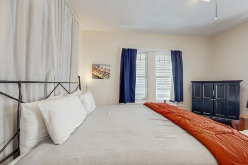 a bedroom with a large bed with blue curtains at Sea Glass Cottage in Galveston