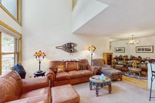 a living room with leather furniture and a table at Cimarron Mountain Retreat in Telluride