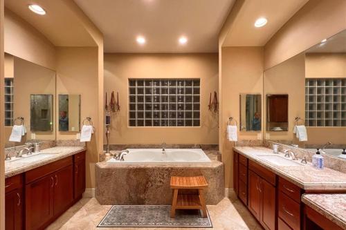 Un baño grande con dos lavabos y una bañera. en Villa Barhi - A Mediterranean Palazzo, en Thousand Palms