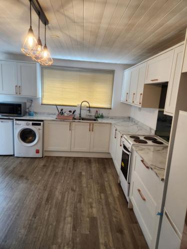 a kitchen with white cabinets and a sink at Okwute,s House in Skelmersdale
