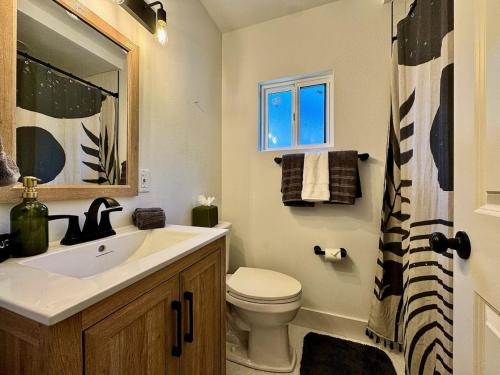 a bathroom with a sink and a toilet and a window at Pool Remodeled 4 Bedroom Carmichael Home in Carmichael